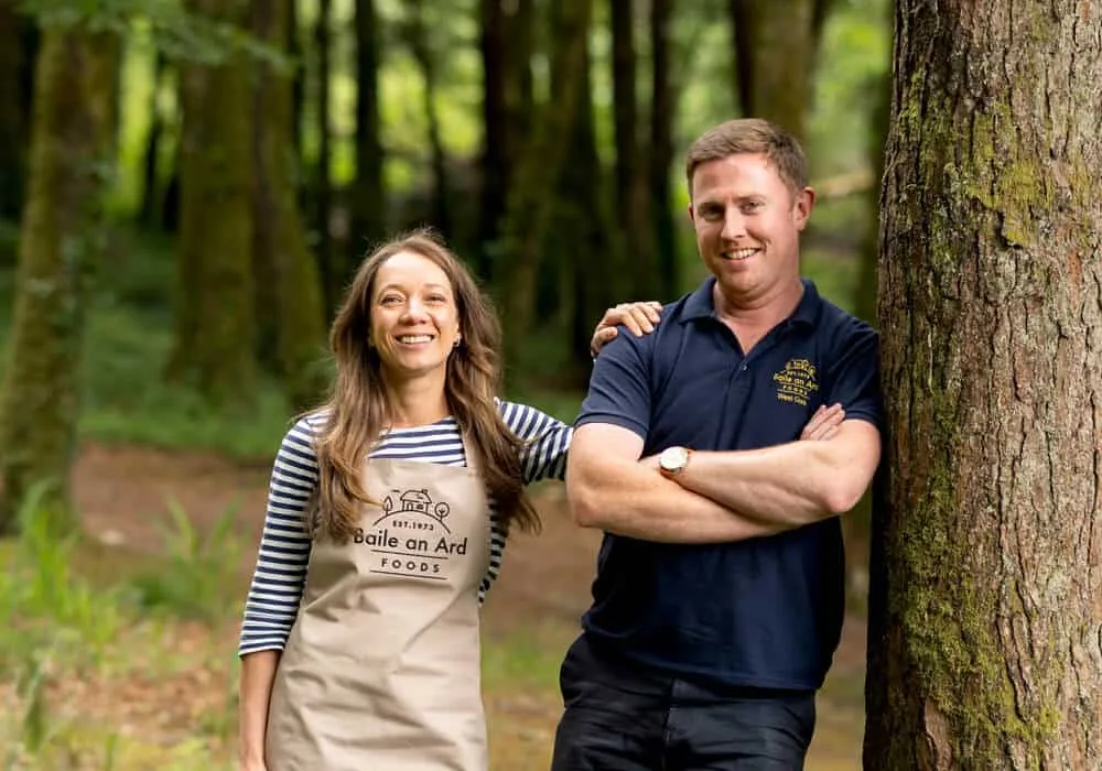 Photo of Baile an Ard Foods owners - Stephen and Sarah smiling in a forest