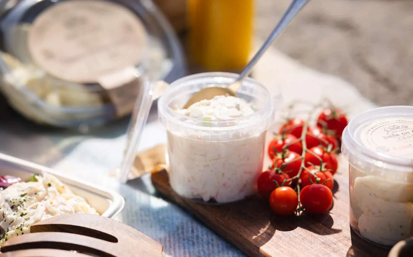 Assorted Baile an Ard Foods salads and tomatoes on a wooden board.