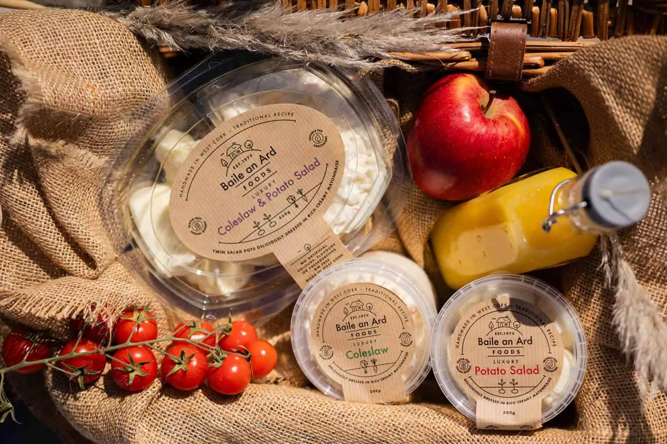 Coleslaw and potato salad with tomatoes, apple, and juice.